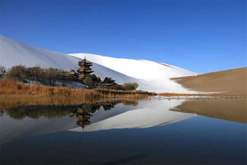 鳴沙山月牙泉景區(qū)雪景。敦煌市委宣傳部供圖，張曉亮攝